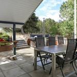 Terrasse mit Tisch, Stühlen und Whirlpool im Grünen