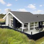 Moderne Villa mit Terrasse und großem Glasbereich in ländlicher Umgebung.