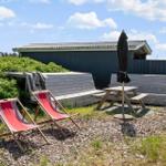 Hinterhof mit Liegestühlen, Picknicktisch und Schirm. Hintergrund: Holzhaus und Zaun.