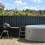 Hinterhof mit Whirlpool, Grill und Tisch neben einem Gebäude.