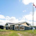 Moderne Strandvilla mit Flagge und Terrasse im Freien.