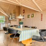 Essbereich mit Tisch, Stühlen und Küchenbereich in Holzhaus
