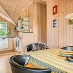 Küche und Essbereich mit Holzwand und -decke, Esstisch mit Stühlen und Fenster.
