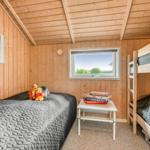 Ein Schlafzimmer mit Doppelbett, Etagenbett und Fenster. Auf dem Bett liegen Plüschtiere.