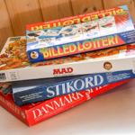 Stapel von Brettspielen auf einer Oberfläche vor Holzwand