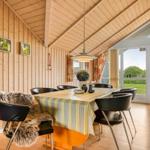 Esszimmer mit Holzwand, Tisch und Stühlen, Blick auf Garten