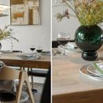 Esstisch mit Stühlen, Blumenvase und Weingläsern. Hintergrund: Wandbild und Deckenleuchte.