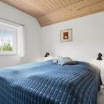 Schlafzimmer mit Bett, Fenster und Holzdecke