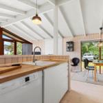 Kitchen with wooden countertop and view of garden. Dining area with table and chairs.