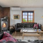 Wohnzimmer mit Kamin, Sofa und Fenster zum Garten