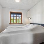 Schlafzimmer mit Bett, Fenster und Wandlampen.