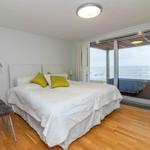 Schlafzimmer mit Blick aufs Meer und Holzboden
