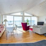 Wohnraum mit Küchenbereich, Blick aufs Meer, rote Sessel und Sofa.