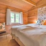 Bedroom with wooden walls, bed, window, and mushroom poster on the wall.