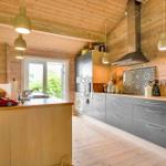 Kitchen with wooden walls, gray cabinets, and window to outside.