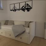 Schlafzimmer mit weißem Bett, Wandbild und Holzboden.