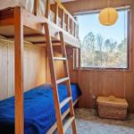 Kammer mit Holz-Bett, Fenster und Korb.