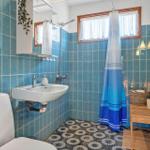 Badezimmer mit blauen Fliesen, Dusche und Waschbecken