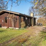 Holzhaus mit Terrasse, Garten und Grill. Außendusche und Sitzgelegenheiten.
