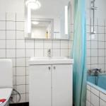 Badezimmer mit Toilette, Waschbecken und Badewanne mit Duschvorhang.