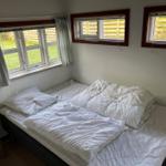 Bedroom with bed, windows, and nightstand.