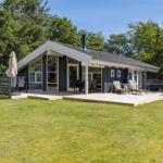 Modern holiday home with terrace, garden, and barbecue area. Surrounded by trees.