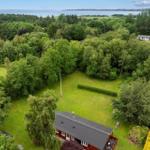 Rotes Haus mit Garten und Wald, Blick auf See