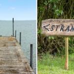 Holzsteg führt zum Wasser. Schild weist auf Strand hin.