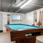 Billiard table with blue felt and wooden frame in a room with tools on the wall.