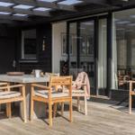 Terrasse mit Holztisch und Stühlen unter Dach