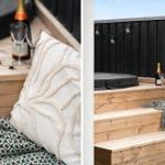Terrasse mit Holzbank, Kissen und Champagner. Hintergrund: schwarze Holzwand und Lichterkette.