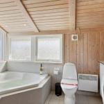 Bad mit Whirlpool, Toilette und Waschmaschine. Holzwand und -decke.