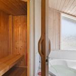 Sauna mit Holzbank und Badewanne mit Fenster