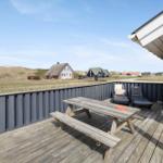 Terrasse mit Picknicktisch, Liegestühlen und Blick auf Strandhäuser.