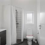 Badezimmer mit Dusche, Toilette und Waschbecken mit Spiegel
