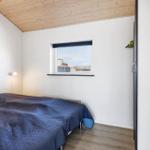 Schlafzimmer mit Bett, Fenster und Holzdecke.