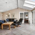 Wohnzimmer mit Ledersofa, Holztisch und Blick auf Garten