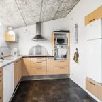 Küche mit Holzschränken, Spüle, Kühlschrank und Backofen.