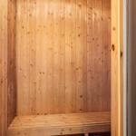 Holzsauna mit Bank und vertikalen Wandpaneelen.