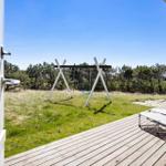 Terrasse mit Liegen und Schaukel im Grünen