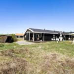 Schwarze Hütte mit Terrasse und Garten. Spielplatz und Grillplatz vorhanden.