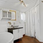 Badezimmer mit Badewanne, Waschtisch und Duschvorhang.