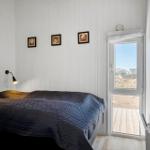 Schlafzimmer mit Bett, Wandbildern und Tür zum Balkon.