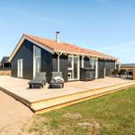 Moderne Strandhaus mit Holzterrasse, Liegestühlen und Garten.