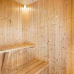 Sauna mit Holzwandverkleidung und Sitzbänken.