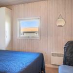 Schlafzimmer mit Bett, Kleiderschrank und Fenster. An der Wand hängt ein runder Spiegel.
