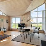 Wohn- und Essbereich mit Holzwand, großen Fenstern und moderner Einrichtung.