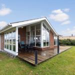 Ein Haus mit Holzterrasse und großen Fenstern im Freien.