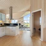 Küche mit Essbereich und Schlafzimmer. Holzvertäfelung und große Fenster.