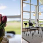 Esszimmer mit großem Fenster, Tisch und Stühlen, Tulpen im Vordergrund.